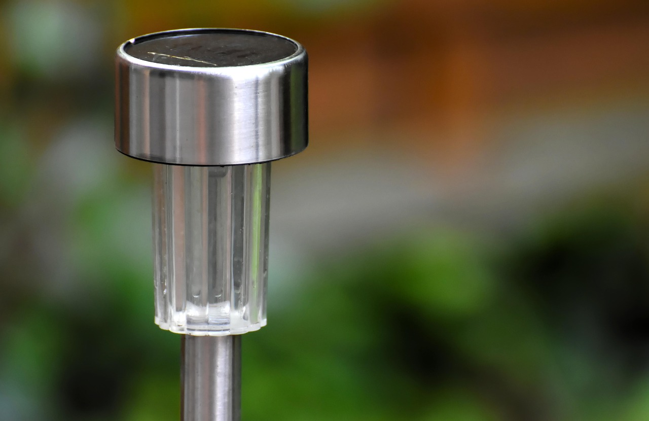 Solarleuchte aus Edelstahl und Glas im Gartenbeet