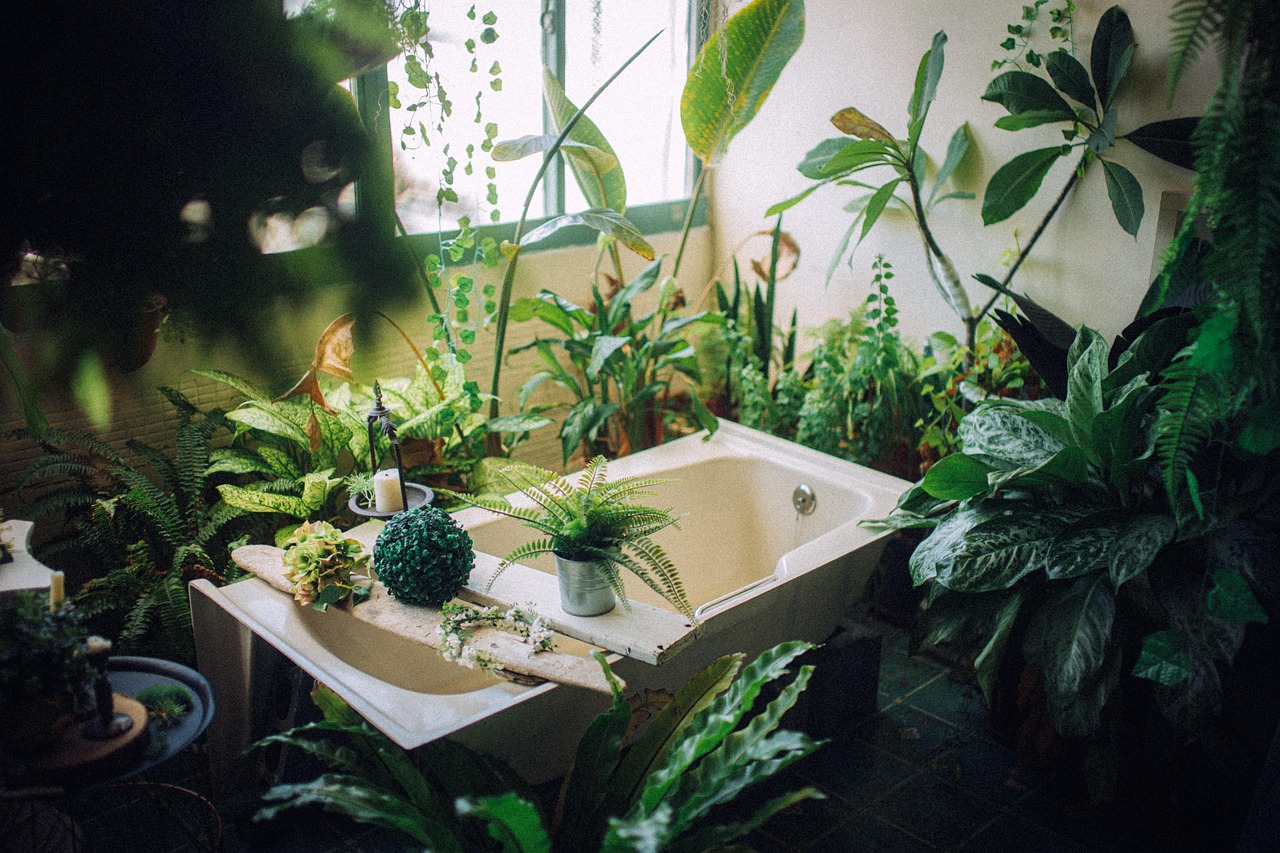 Badezimmer mit zahlreichen Grünpflanzen rund um die Badewanne