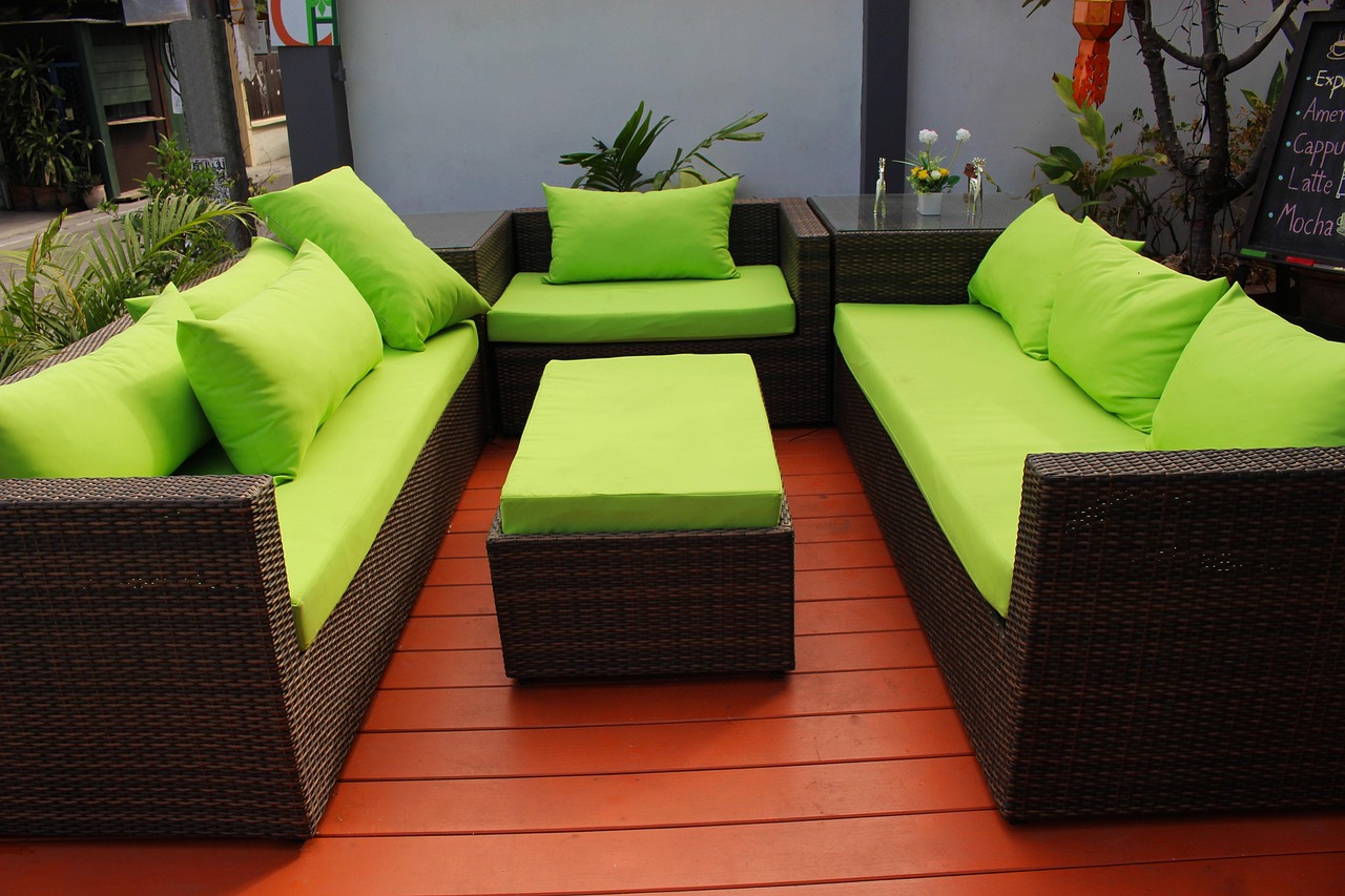 Loungemöbel aus Polyrattan mit grünen Polstern auf einer Terrasse
